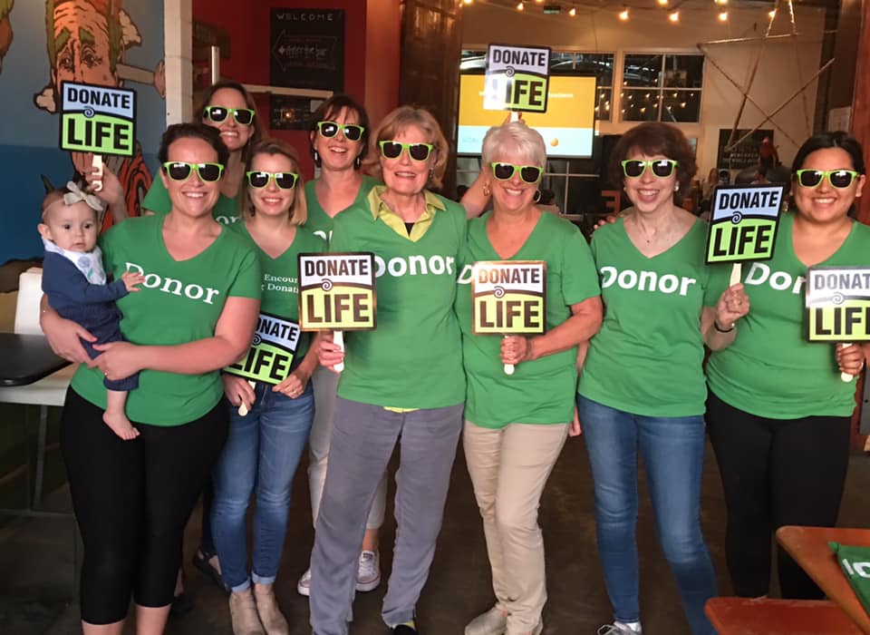 A picture of WELD members wearing DONOR tee shirts and holding signs that say "Donate Life." The caption tells where Michele is standing.